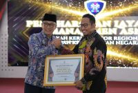 TERSENYUM: Bupati Sumenep, Achmad Fauzi Wongsojudo saat menerima penghargaan dari BKN Atas diraihnya Layanan Penetapan NIP Terbaik di wilayah kerja Kantor Regional II BKN Surabaya (Doc. Istimewa)