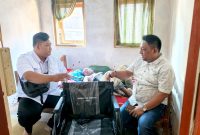 BERBICARA: Baznas Sumnep saat menyerahkan bantuan Kursi Roda kepada penderita lumpuh Bapak Ilyas Adi, di Desa Banasare, Kacamatan Rubaru, yang didampingi Ketua IWO Sumenep (Mufti Che -Seputar Jatim)