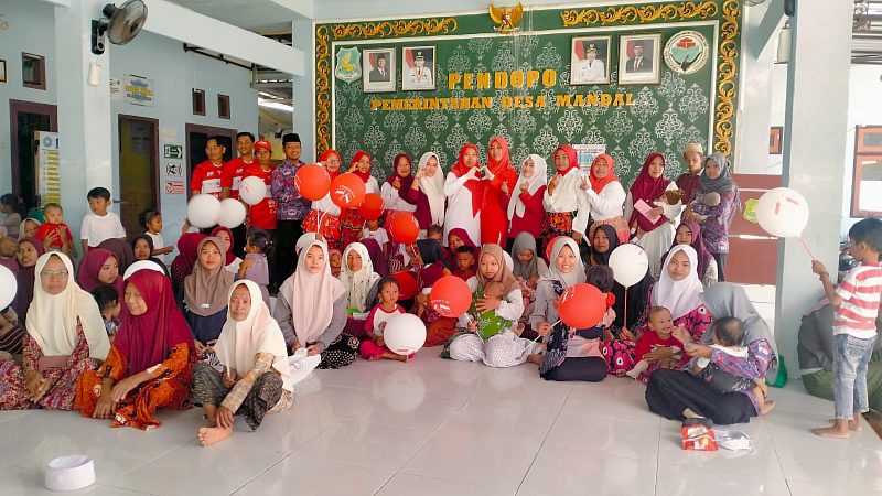KOMPAK: Tim Kesehatan dari Puskesmas Rubaru saat foto bersama dengan Kader Posyandu Anggrek, dan warga di Balai Desa Mandala Rubaru, usai kegiatan vaksinasi massal (Doc. Seputar Jatim)