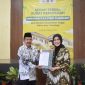 TERSENYUM: Ketua LLDIKTI Wilayah VII Jawa Timur,  Dyah Sawitri (kanan) saat menyerahkan Salinan Keputusan Menteri Pendidikan Tinggi kepada Ketua PPLP-PT PGRI Sumenep, Sunarjo (kiri) (SandiGT - Seputar Jatim)