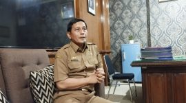 SANTAI: Kepala Dinsos P3A Sumenep, Mustangin, saat menyampaikan tentang DBHCHT di ruangannya (SandiGT - Seputar Jatim)