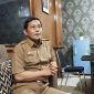 SANTAI: Kepala Dinsos P3A Sumenep, Mustangin, saat menyampaikan tentang DBHCHT di ruangannya (SandiGT - Seputar Jatim)