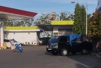 SANTAI: Terlihat sesorang mendorong jerigen berisi BBM Solar yang akan diangkut ke mobil Pick Up hitam di SPBU Patean Sumenep (SandGT- Seputar Jatim)