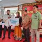 BERJEJER: Kepala Disnaker Sumenep, Heru Susanto, (kiri) bersama Bupati Sumenep, Achmad Fauzi Wongsojudo (tengah) saat menyerahkan BPJS Ketenagakerjaan secara simbolis kepada salahsatu pekerja (SandiGT - Seputar Jatim) 