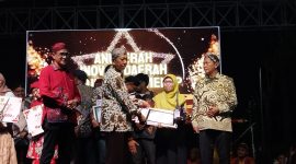 SERAH TERIMA: Kepala Bidang Pelayanan Pendaftaran Penduduk Disdukcapil Sumenep, Wahasah, saat menerima penghargaan inovasi daerah 2025, yang diberikan oleh Plt Sekda R. Achmad Syahwan Effendy (SandiGT - Seputar Jatim) 