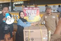 JABAT TANGAN: Kepala Bidang PPD Bapenda Sumenep, Akhmad Sugiharto, saat menyerahkan kulkas pada kegiatan gerebek pajak 2025 (SandiGT - Seputar Jatim)