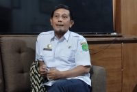 BERSANTAI: Kepala Dinas Sosial, Pemberdayaan Perempuan dan Perlindungan Anak (Dinsos P3A) Kabupaten Sumenep, Mustangin, saat berada di kantornya (SandiGT - Seputar Jatim)