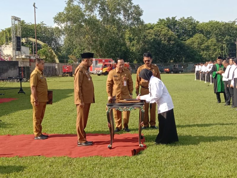 PENANDATANGANAN: Bupati Sumenep, Achmad Fauzi Wongsojudo, saat menyerahkan SK PPPK Paruh Waktu, yang didampingi Plt. Kepala BKPSDM Sumenep, Arif Frimanto di di Stadion GOR A. Yani Pangligur (Mufti Che - Seputar Jatim)
