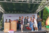 BAHAGIA: Ketua SMSI Kabupaten Sumenep, Wahyudi, saat memberikan hadiah utama sepeda listrik (Mufti Che - Seputar Jatim)