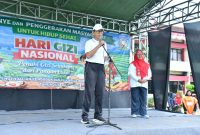 BERDIRI: Plt Sekda Kabupaten Sumenep, R. Syahwan Efendi (depan) bersama Kepala Dinkes P2KB Kabupaten Sumenep, Ellya Fardasah (belakang) saat memberikan sambutan di acara HGN ke 66 (SandiGT - Seputar Jatim)