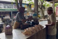 TRANSAKSI: Penjual daging ayam potong di pasar anom Sumenep saat melakukan jual beli (SandiGT - Seputar Jatim)