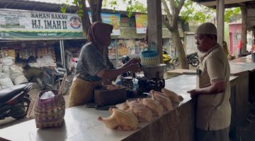 TRANSAKSI: Penjual daging ayam potong di pasar anom Sumenep saat melakukan jual beli (SandiGT - Seputar Jatim)
