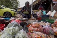 BERDAGANG: Penjual cabai rawit di Pasar Anom Sumenep saat membungkus dagangannya (SandiGT - Seputar Jatim)
