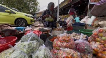 BERDAGANG: Penjual cabai rawit di Pasar Anom Sumenep saat membungkus dagangannya (SandiGT - Seputar Jatim)