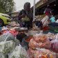 BERDAGANG: Penjual cabai rawit di Pasar Anom Sumenep saat membungkus dagangannya (SandiGT - Seputar Jatim)