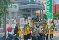 SEMANGAT: Para pegawai BPRS Bhakti Sumekar saat membagikan takjil kepada para pengguna jalan di depan kantor pusat (Doc. Seputar Jatim)