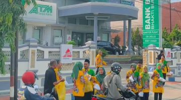 SEMANGAT: Para pegawai BPRS Bhakti Sumekar saat membagikan takjil kepada para pengguna jalan di depan kantor pusat (Doc. Seputar Jatim)