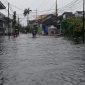 HUJAN: Pengendara roda dua saat melewati jalan yang tergenang banjir di Bumi Sumeker Kolor Kota Sumenep (Doc. Seputar Jatim)