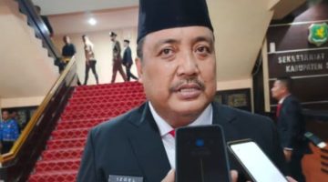DICEGAT: Plt. Kepala Dinas Perumahan Rakyat, Kawasan Permukiman, dan Perhubungan (Disperkimhub) Sumenep, Achmad Dzulkarnain, saat diwawancarai wartawan. (SandiGT – Seputar Jatim)