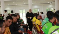 BAHAGIA: Seorang perempuan membagikan bantuan kepada para pengemudi ojek online saat kegiatan sosial Ramadan di Islamic Center Sumenep (Doc. Seputar Jatim)