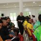 BAHAGIA: Seorang perempuan membagikan bantuan kepada para pengemudi ojek online saat kegiatan sosial Ramadan di Islamic Center Sumenep (Doc. Seputar Jatim)