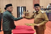 BERSINERGI: Ketua DPRD Sumenep, Zainal Arifin (kiri) saat bersalaman dengan Bupati Sumenep, Achmad Fauzi Wongsojudo (kanan) di acara rapat paripurna (SandiGT - Seputar Jatim)