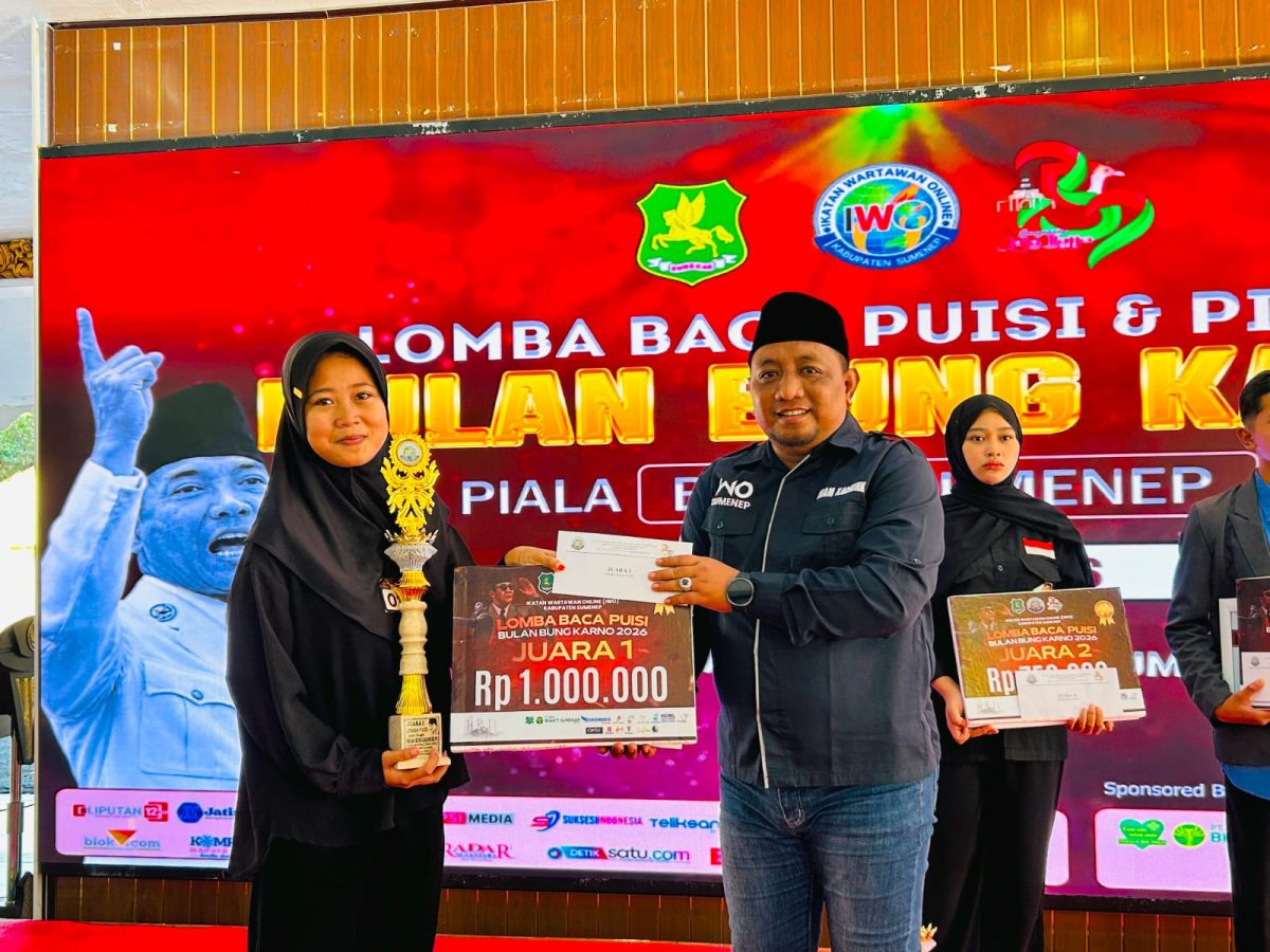 TERSENYUM: Ketua IWO Sumenep, Imam Mustain R, saat memberikan hadiah kepada pemenang juara I lomba puisi karya Bung Karno (Mufti Che - Seputar Jatim)