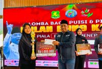 TERSENYUM: Ketua IWO Sumenep, Imam Mustain R, saat memberikan hadiah kepada pemenang juara I lomba puisi karya Bung Karno (Mufti Che - Seputar Jatim)