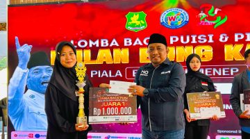 TERSENYUM: Ketua IWO Sumenep, Imam Mustain R, saat memberikan hadiah kepada pemenang juara I lomba puisi karya Bung Karno (Mufti Che - Seputar Jatim)