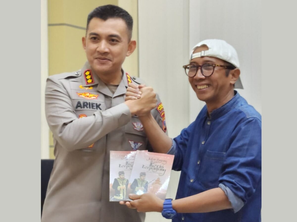 TERSENYUM: Kapolresta Sumenep Kombes Pol. Ariek Indra Sentanu, saat menerima buku karya Bupati dari Tenaga Ahli (TA) Bupati Sumenep Bidang Ilmu Pengetahuan dan Teknologi (Iptek) serta Kebudayaan, Ibnu Hajar (Doc. Seputar Jatim)