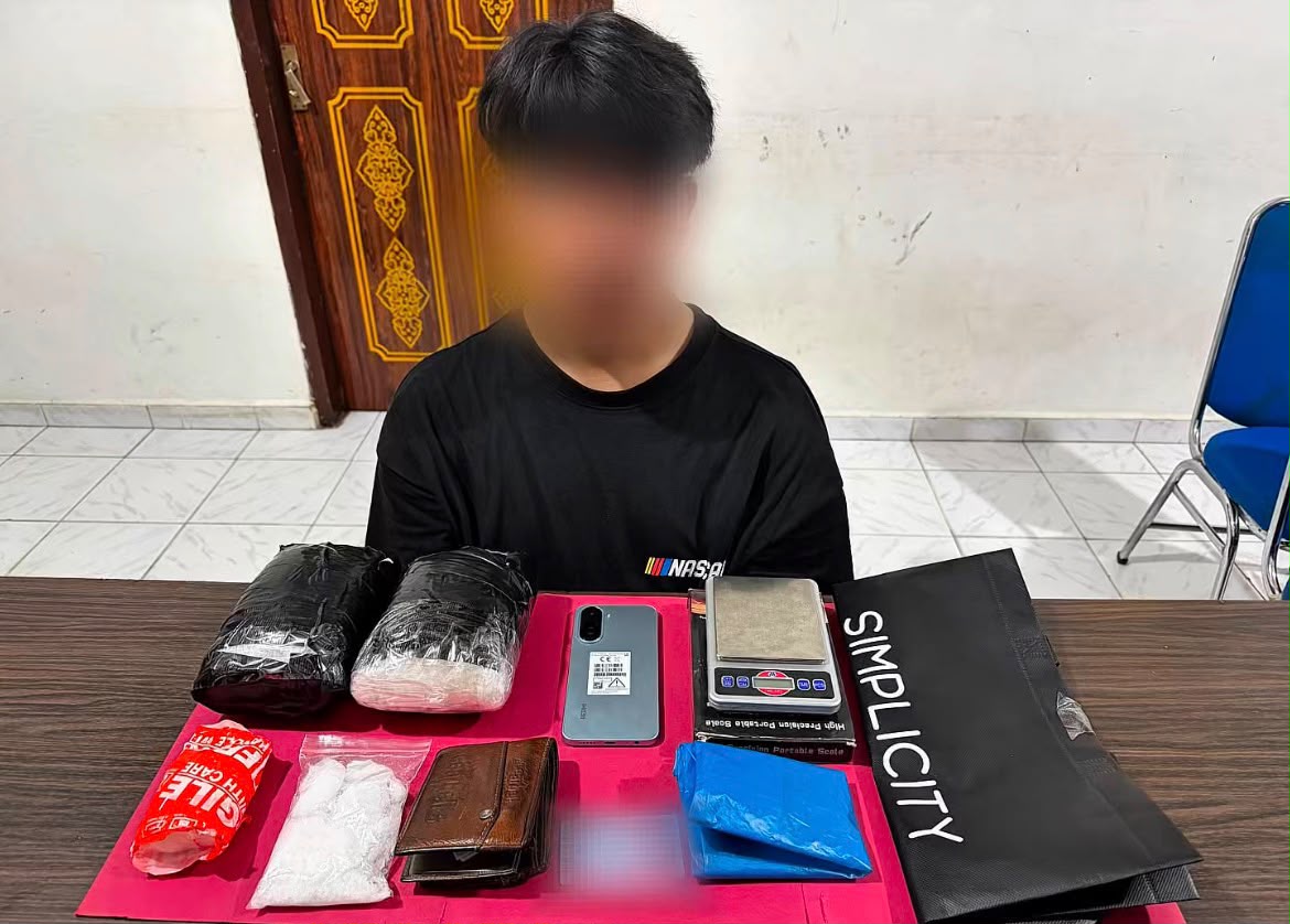 TERTANGKAP: Pelaku saat menunjukkan barang bukti sabu seberat sekitar 2,2 kilogram yang berhasil diamankan dari seorang penumpang di Bandara Sultan Syarif Kasim (SSK) II Pekanbaru (Foto Istimewa)