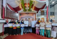 BERDIRI: Buruh tembakau saat melakukan foto bersama dengan Bupati Sumenep, usai menerima BLT DBHCHT secara simbolis (Doc. Seputar Jatim)