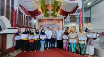 BERDIRI: Buruh tembakau saat melakukan foto bersama dengan Bupati Sumenep, usai menerima BLT DBHCHT secara simbolis (Doc. Seputar Jatim)