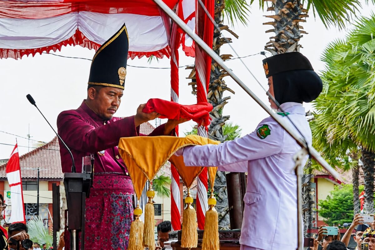 MENYERAHKAN: Bupati Sumenep Achmad Fauzi Wongsojudo, saat memberikan Bendera Merah Putih, untuk prosesi upacara peringatan HUT ke-81 Kemerdekaan RI di Kabupaten Sumenep (Dok. Seputar Jatim)