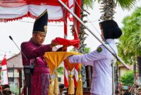 MENYERAHKAN: Bupati Sumenep Achmad Fauzi Wongsojudo, saat memberikan Bendera Merah Putih, untuk prosesi upacara peringatan HUT ke-81 Kemerdekaan RI di Kabupaten Sumenep (Dok. Seputar Jatim)