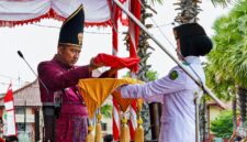 MENYERAHKAN: Bupati Sumenep Achmad Fauzi Wongsojudo, saat memberikan Bendera Merah Putih, untuk prosesi upacara peringatan HUT ke-81 Kemerdekaan RI di Kabupaten Sumenep (Dok. Seputar Jatim)