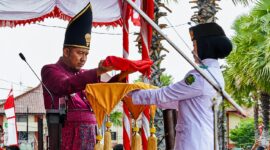 MENYERAHKAN: Bupati Sumenep Achmad Fauzi Wongsojudo, saat memberikan Bendera Merah Putih, untuk prosesi upacara peringatan HUT ke-81 Kemerdekaan RI di Kabupaten Sumenep (Dok. Seputar Jatim)