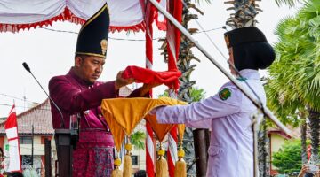 MENYERAHKAN: Bupati Sumenep Achmad Fauzi Wongsojudo, saat memberikan Bendera Merah Putih, untuk prosesi upacara peringatan HUT ke-81 Kemerdekaan RI di Kabupaten Sumenep (Dok. Seputar Jatim)