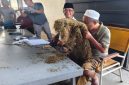 MENCIUM: Pengusaha Rokok, Aba H. Mu’min saat mengecek tembakau di gudang Desa Daramista, Kecamatan Lenteng, Kabupaten Sumenep (Dok. Seputar Jatim)