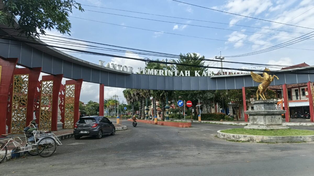 CERAH: Pintu masuk Kantor Pemerintah Kabupaten Sumenep tampak dari depan, dengan sejumlah kendaraan, termasuk becak dan mobil, melintasSeputar Jatim)