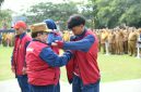 BERSEMANGAT: Wakil Bupati Sumenep, KH. Imam Hasyim, memakaikan jaket kontingen kepada atlet pelajar Kabupaten Sumenep saat pelepasan menuju POPDA Jatim XV 2026 (Dok. Seputar Jatim)
