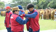 BERSEMANGAT: Wakil Bupati Sumenep, KH. Imam Hasyim, memakaikan jaket kontingen kepada atlet pelajar Kabupaten Sumenep saat pelepasan menuju POPDA Jatim XV 2026 (Dok. Seputar Jatim)