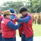 BERSEMANGAT: Wakil Bupati Sumenep, KH. Imam Hasyim, memakaikan jaket kontingen kepada atlet pelajar Kabupaten Sumenep saat pelepasan menuju POPDA Jatim XV 2026 (Dok. Seputar Jatim)